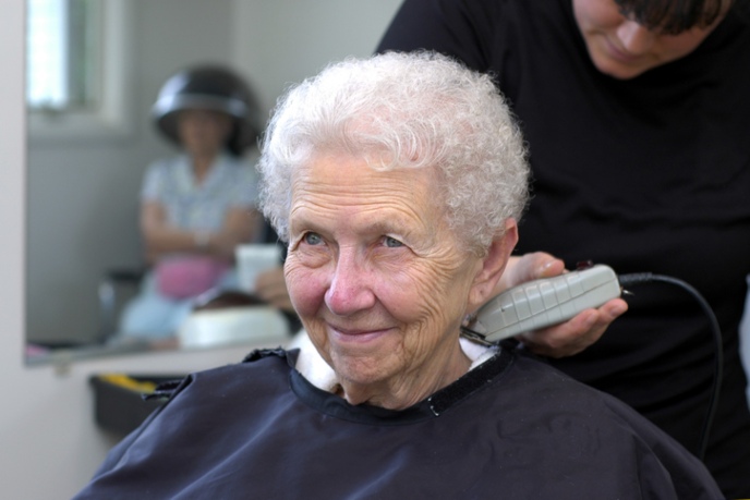 Senior woman getting a haircut at The Gables Assisted Living facility in Spring Lake