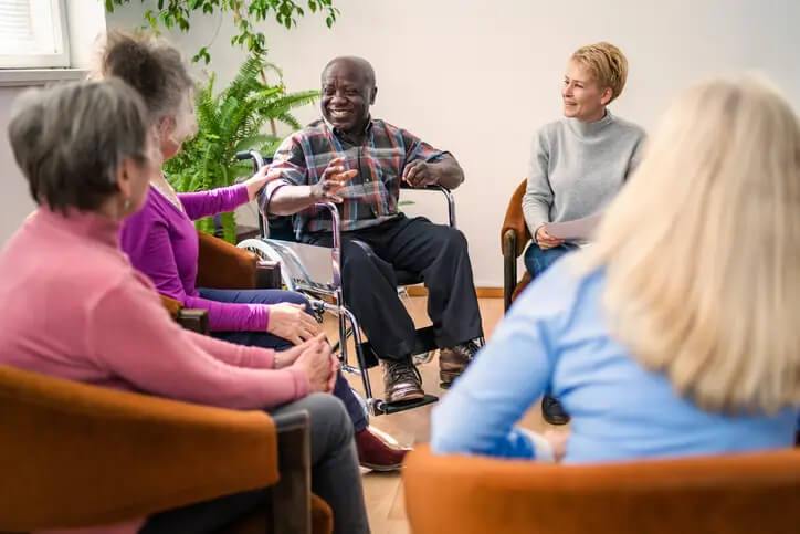 Seniors chatting with a counselor during a therapy session in a residential care home in Spring Lake