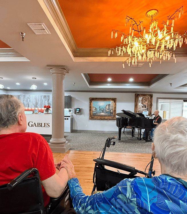 Residents enjoy a live piano performance in a warmly lit common area in Shreveport, LA
