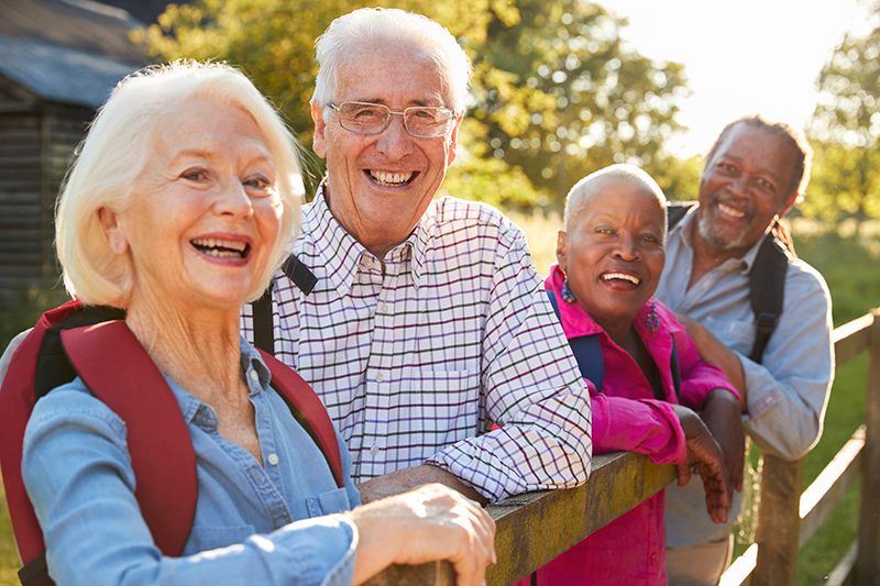 Group of adults enjoying an outdoor walk by a wooden fence in Shreveport, LA