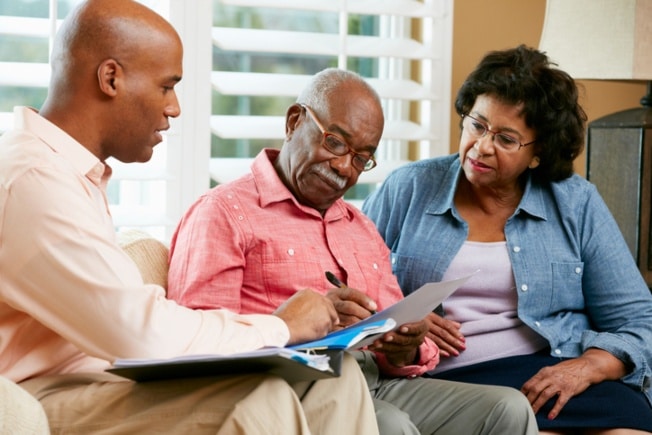 Son discussing nursing home information with elderly parents