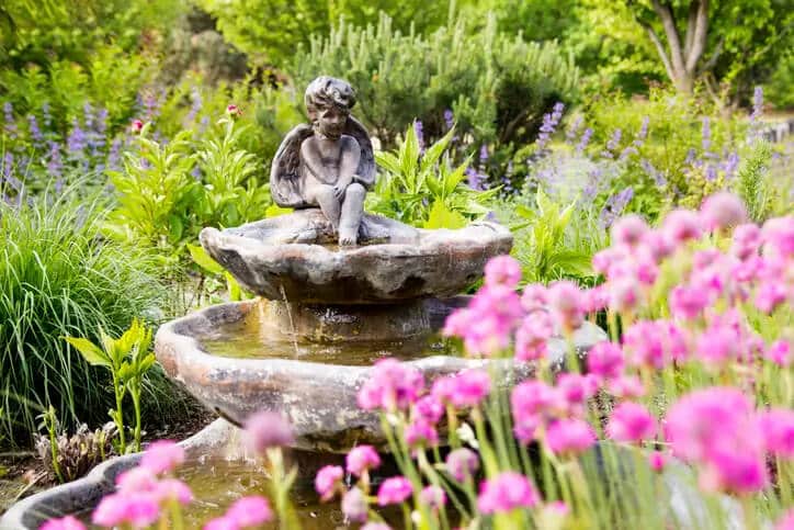 Winged angel sits on bronze colored plaster fountain